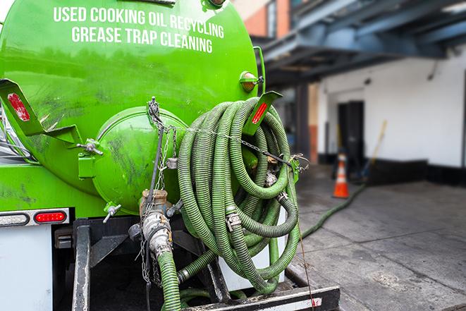 a technician pumping a grease trap in a commercial building in Clarkston MI